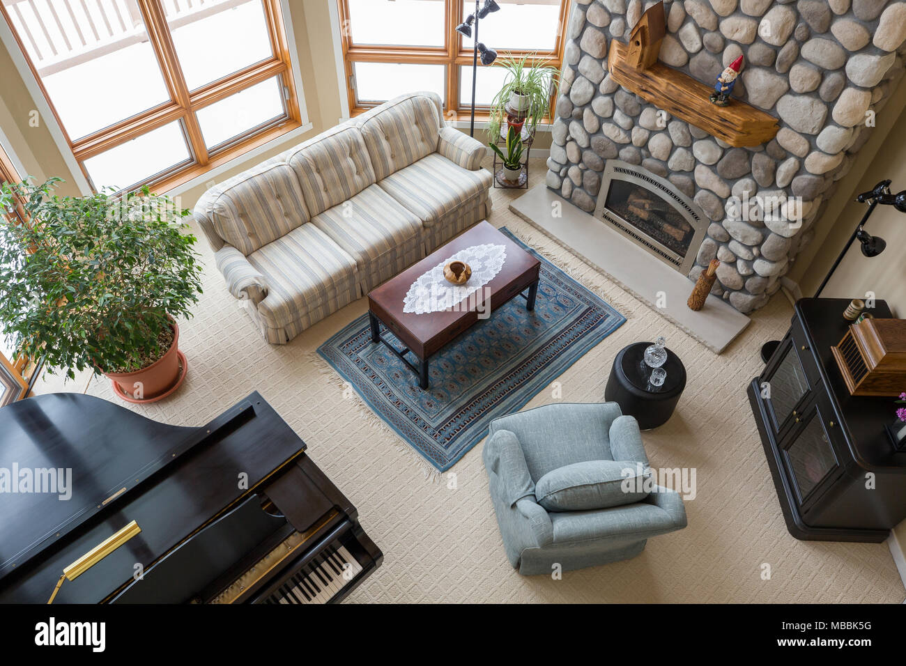 Upscale living room seen from above including piano, floor to ceiling  fireplace, and modern decor Stock Photo - Alamy