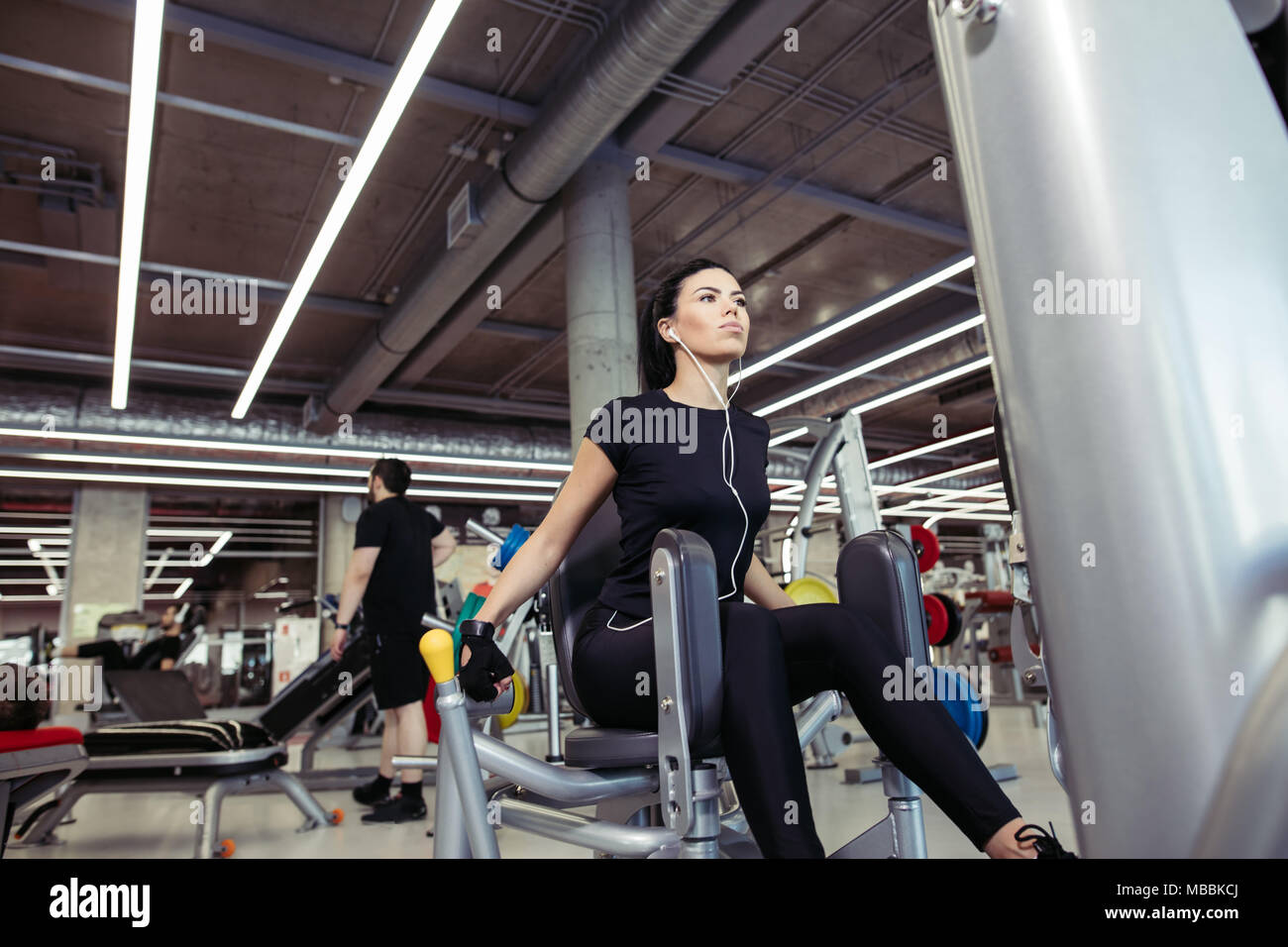 Adduction or abductor machine. girl exercising her legs in gym Stock Photo