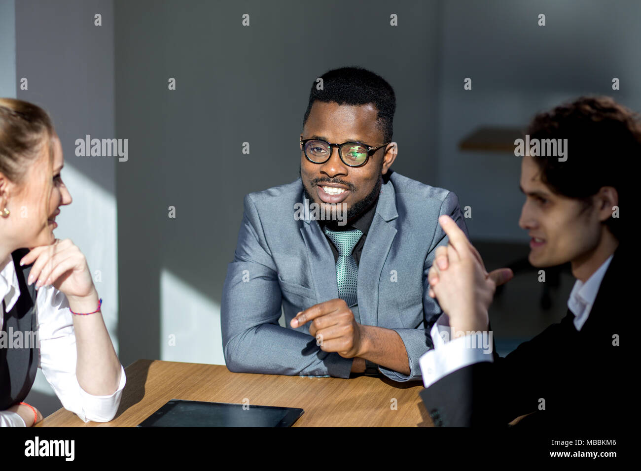 Business people listening to marketing professional african speaker presentation Stock Photo