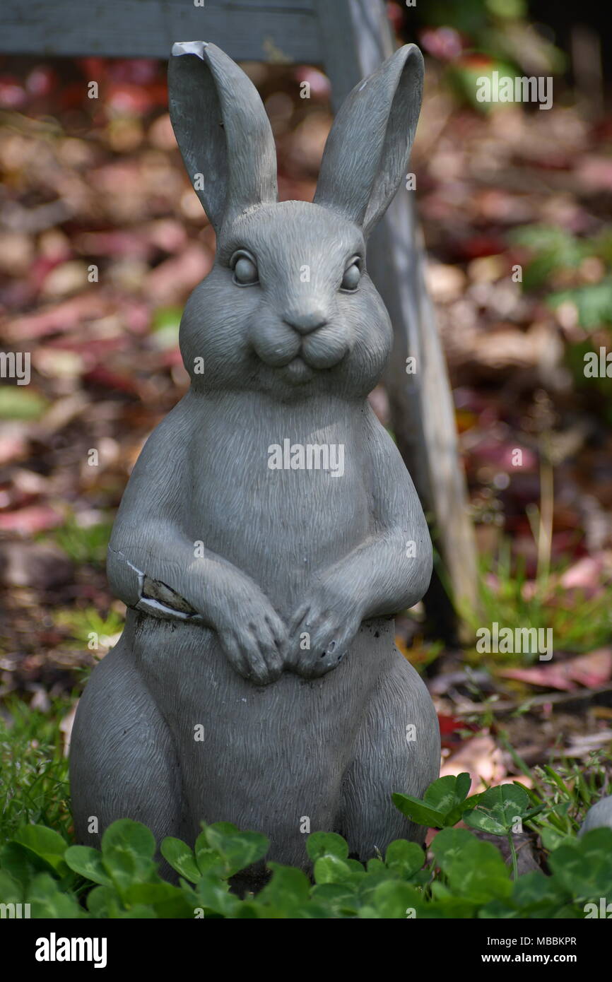 Stone bunny chillin' in the garden Stock Photo