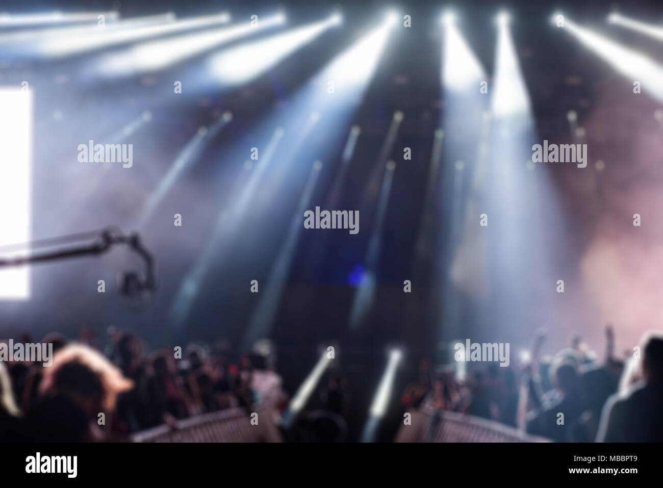 Blurred background with crowd of people partying and stage lights at a ...