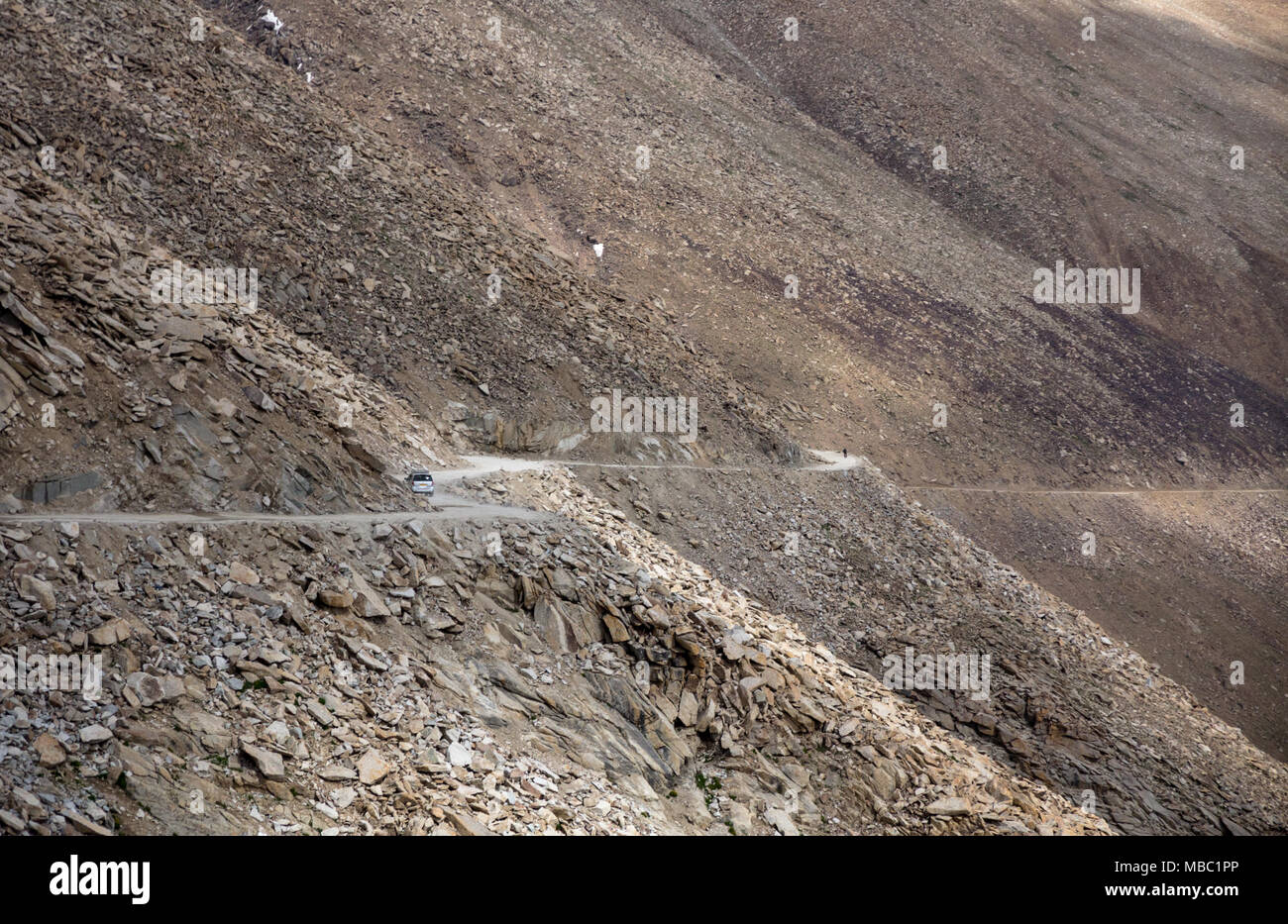 With little moisture in the dry air of the Himalayan rain shadow, there is no vegetation to hide view of road to Khardung pass, north of Leh, India Stock Photo