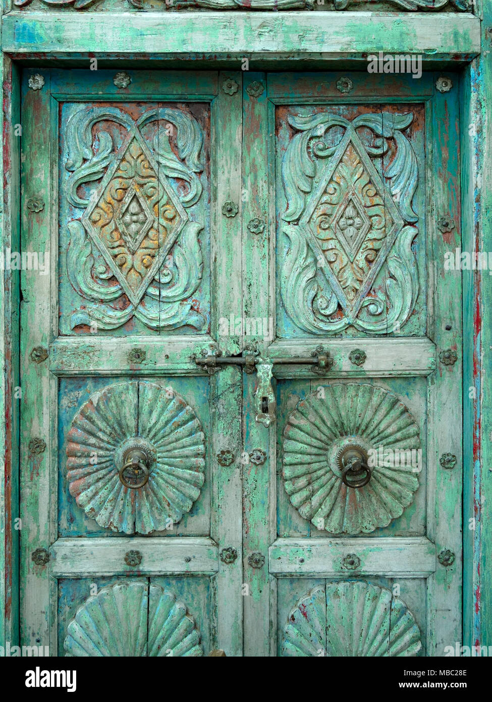 Old distressed ornate antique wooden double doors in Garden Classics reclamation Yard, Ashwell, Rutland, UK Stock Photo