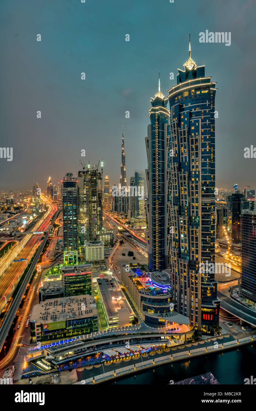 A view of tall buildings in the Business Bay area illuminated at night in Dubai, UAE, Middle East. Stock Photo