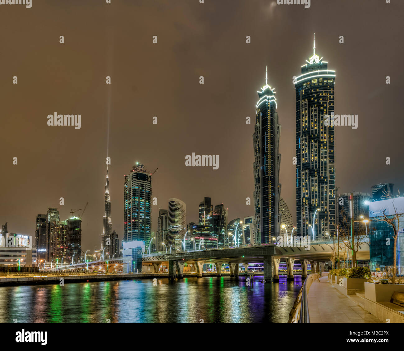 A view of tall buildings in the Business Bay area illuminated at night in Dubai, UAE, Middle East. Stock Photo