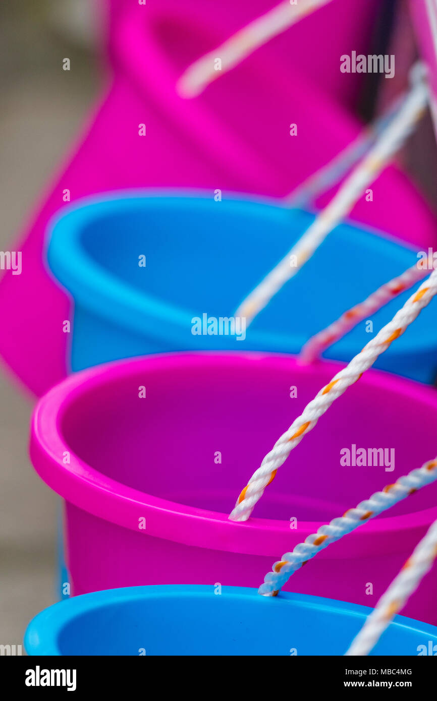 Come brightly coloured plastic buckets in blue and pink material