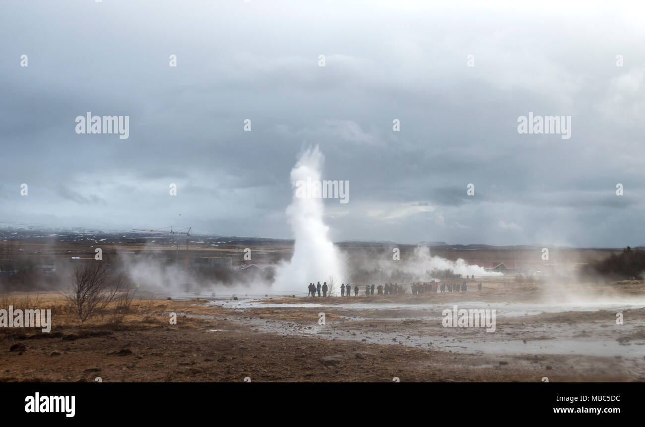 People watching the eruption of Geysir Strokkur, Haukadalur Geothermal Field, Golden Circle, South Iceland, Iceland Stock Photo