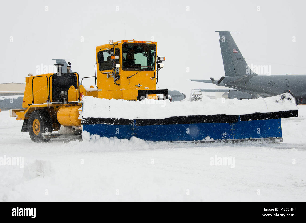 The 92nd Civil Engineer Squadron snow removal trucks clear the flight line at Fairchild Air Force Base, Washington, Feb. 14, 2018. Team Fairchild’s snow removal team uses a variety of large vehicles to keep the flight line clear including snow plows, snow brooms and snow blowers. Team Fairchild’s snow barn is responsible for snow and ice control across the flight line, all aircraft parking areas and taxiways. (U.S. Air Force photo/Senior Airman Janelle Patiño) Stock Photo