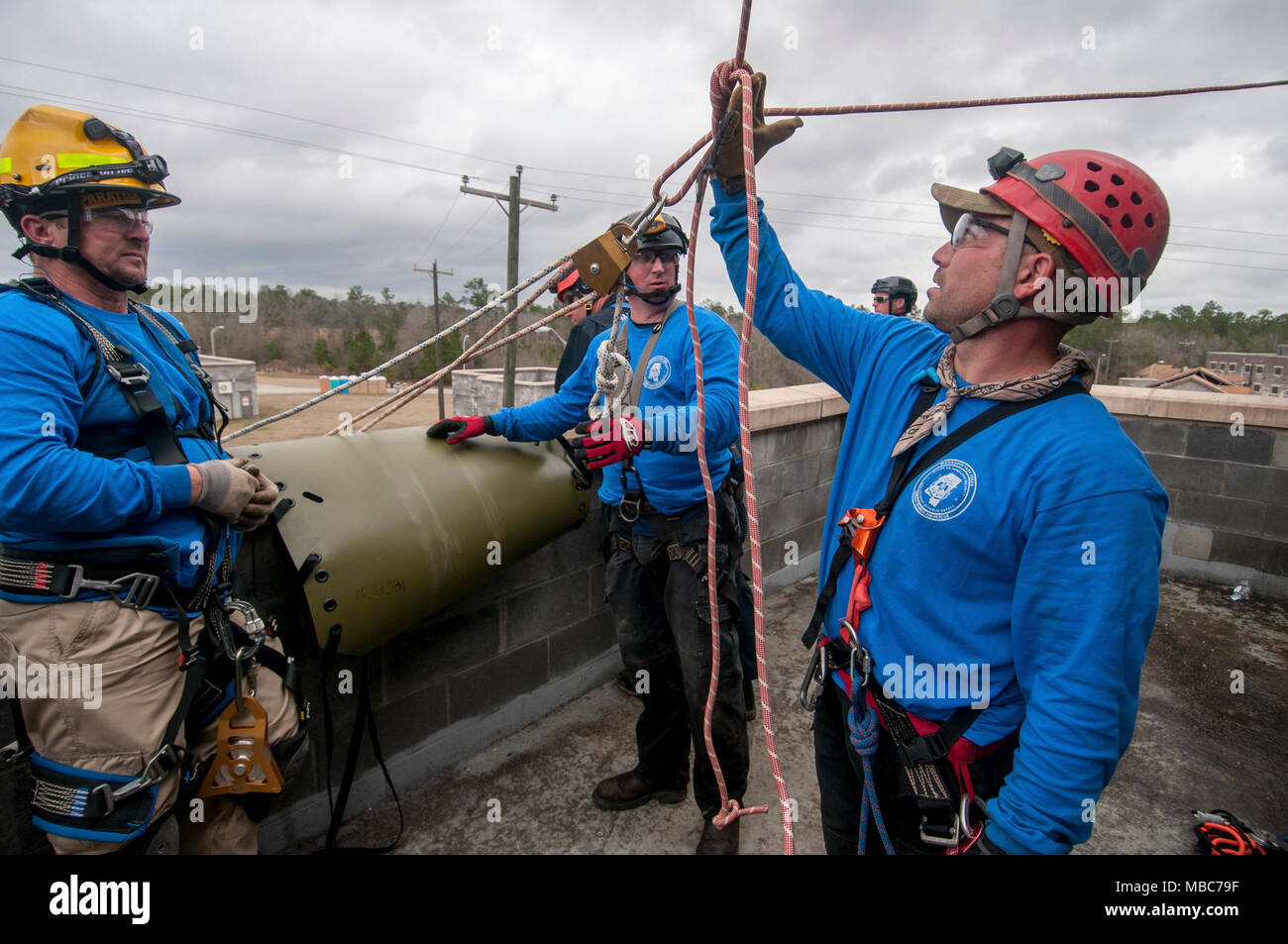 Firefighters from the Mississippi Task Force Urban Search and Rescue team check their knots and angles at which their ropes are stressed, before descending on pulleys and harnesses from the roof of a simulated collapsed building during the training exercise PATRIOT South 18, at Camp Shelby, Miss. on Feb. 14, 2018. PATRIOT South, a joint-agency domestic operations training exercise, focuses on natural disaster preparedness for not only National Guard units from across the nation, but also civilian first responders. (Ohio Air National Guard Stock Photo