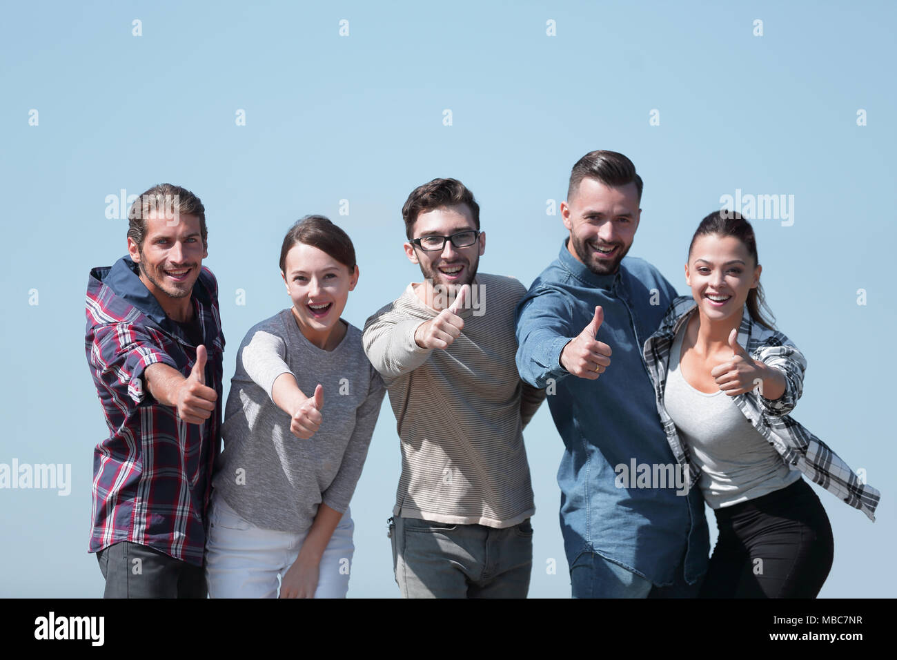 smiling group of young people showing thumb up Stock Photo - Alamy