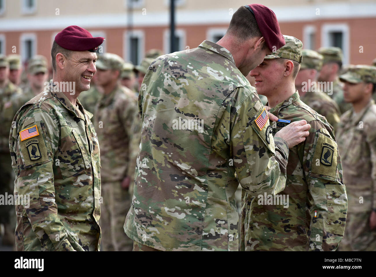 Col. James B. Bartholomees III, Commander of the 173rd Airborne Brigade (right) and Command Sgt. Maj. Franklin Velez of the 173rd Airborne Brigade (left), pins the Expert Infantryman Badge (EIB) on a Paratrooper assigned to the 173rd Airborne Brigade during the Expert Infantryman Badge (EIB) ceremony at Caserma Del Din, Vicenza, Italy, 15 Feb. 2018. (U.S. Army Stock Photo