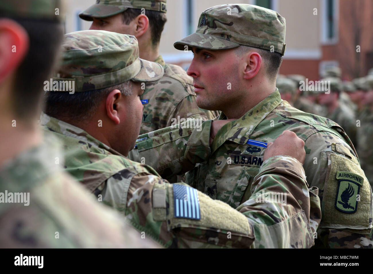 A U.S. Army Paratrooper assigned to the 173rd Airborne Brigade pins the Expert Infantryman Badge (EIB) on a fellow Paratrooper, during the EIB ceremony at Caserma Del Din, Vicenza, Italy, 15 Feb. 2018. (U.S. Army Stock Photo