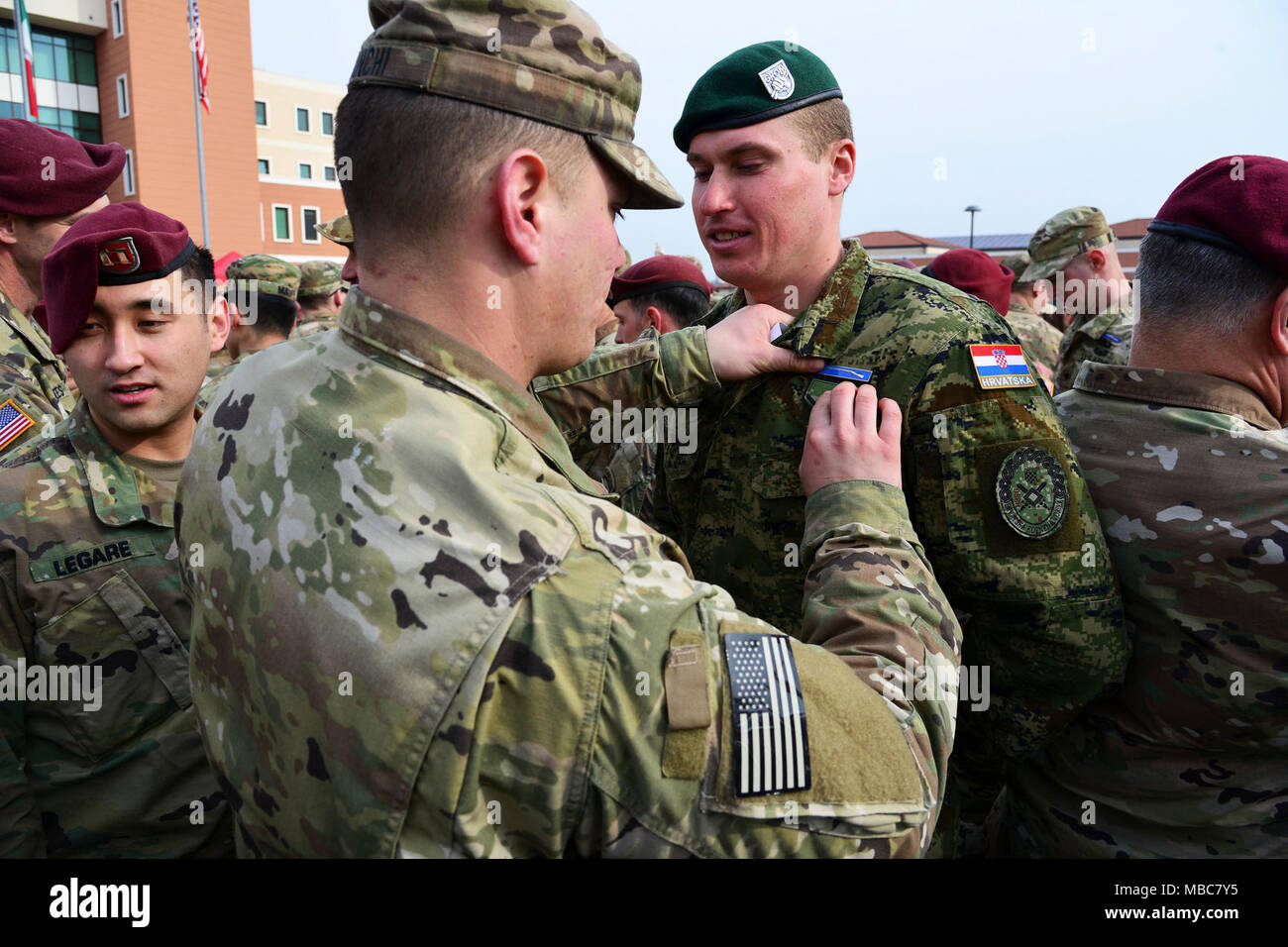 A U.S. Army Solder pins the Expert Infantryman Badge (EIB) on a Croatian Army Soldier during the EIB ceremony at Caserma Del Din, Vicenza, Italy, 15 Feb. 2018. (U.S. Army Stock Photo