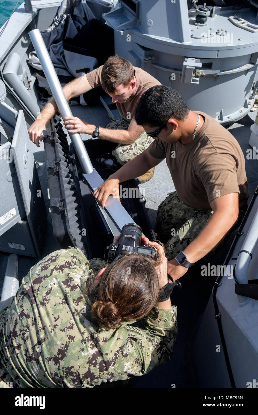 Mass Communication Specialist 1st Class Dominique Lasco, assigned to Fleet Combat Camera Pacific, Det. Guam, documents Chief Gunner's Mate John Zuniga and Electronics Technician 1st Class Ryan Christian, both assigned to Coastal Riverine Group (CRG) 1, Det. Guam, assembling a portable crane for maintenance on a Mark VI patrol craft during routine operations onboard Naval Base Guam, Feb. 15, 2018. CRG-1 Det. Guam is assigned to Commander, Task Force 75, the primary expeditionary task force responsible for the planning and execution of coastal riverine operations, explosive ordnance disposal, di Stock Photo