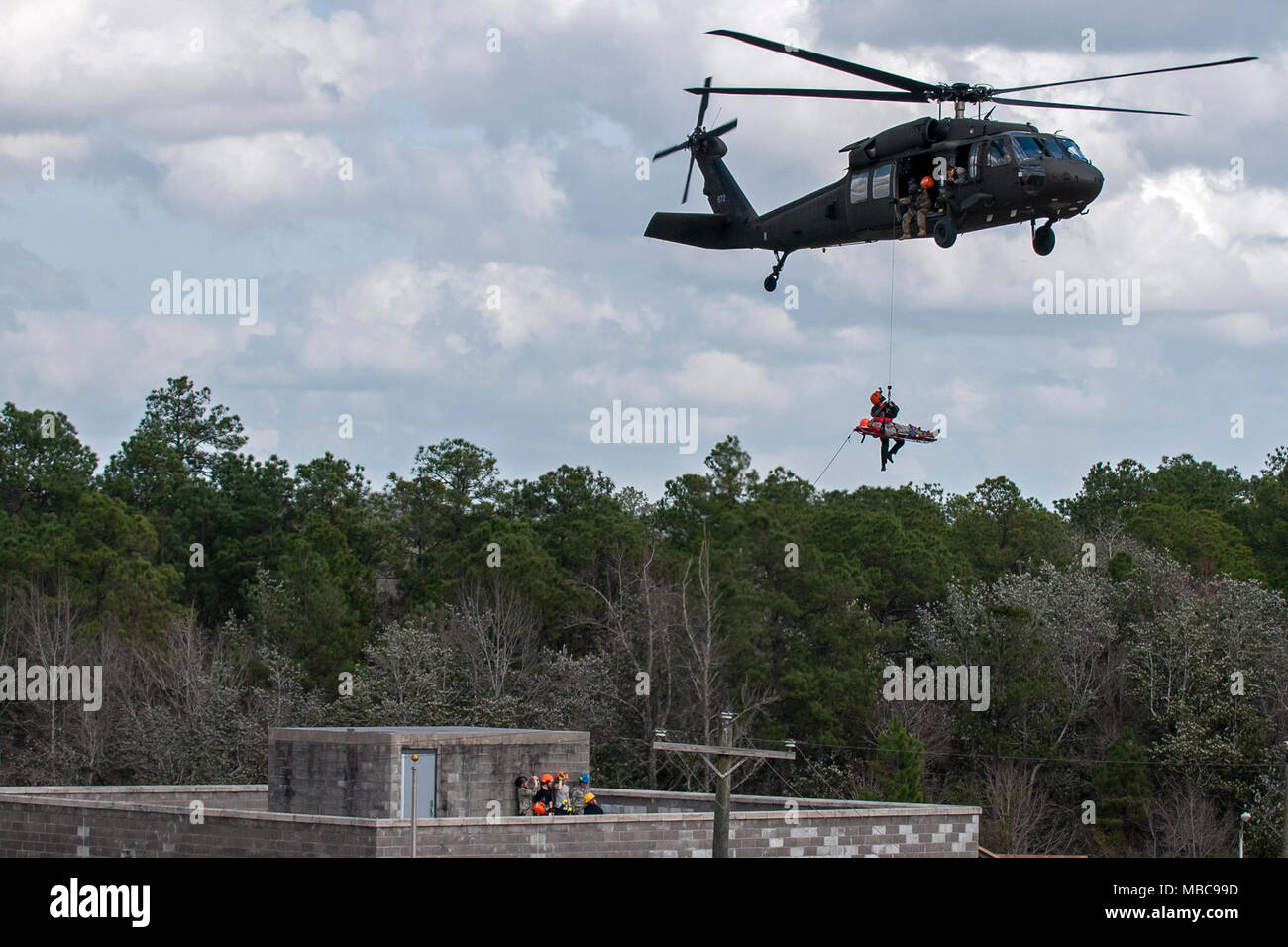 U.S. Army Soldiers with the South Carolina National Guard and members of the South Carolina Helicopter Aquatic Rescue Team use a UH-60 Black Hawk to simulate rescuing survivors from rooftops during the PATRIOT South 18 exercise at Camp Shelby, Miss., Feb. 15, 2018. PATRIOT South 2018 tests the combined abilities of the National Guard, along with state and local agencies, to respond during natural disasters using simulated emergency scenarios. (U.S. Air National Guard Stock Photo
