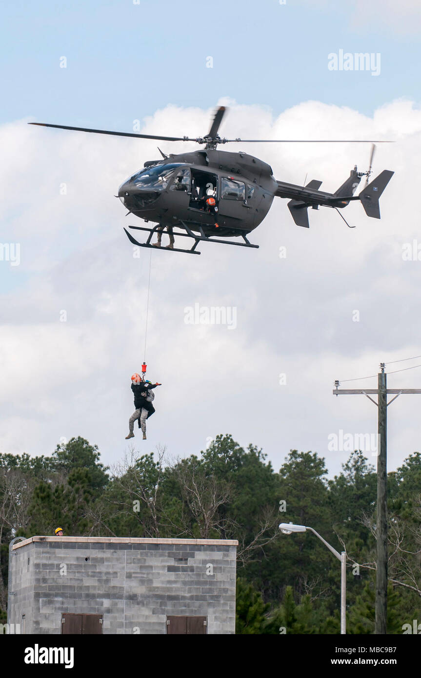 Members of the South Carolina Helicopter Aquatic Rescue Team hoist a simulated natural disaster victim from a roof, with help from a South Carolina Army National Guard UH-72 Lakota helicopter, during the exercise PATRIOT South 18 at Camp Shelby, Miss. on Feb. 15, 2018. PATRIOT South is a joint-agency, domestic operations exercise, focused on natural disaster preparedness and includes National Guard and civilian first responder units from across the country. (Ohio Air National Guard Stock Photo