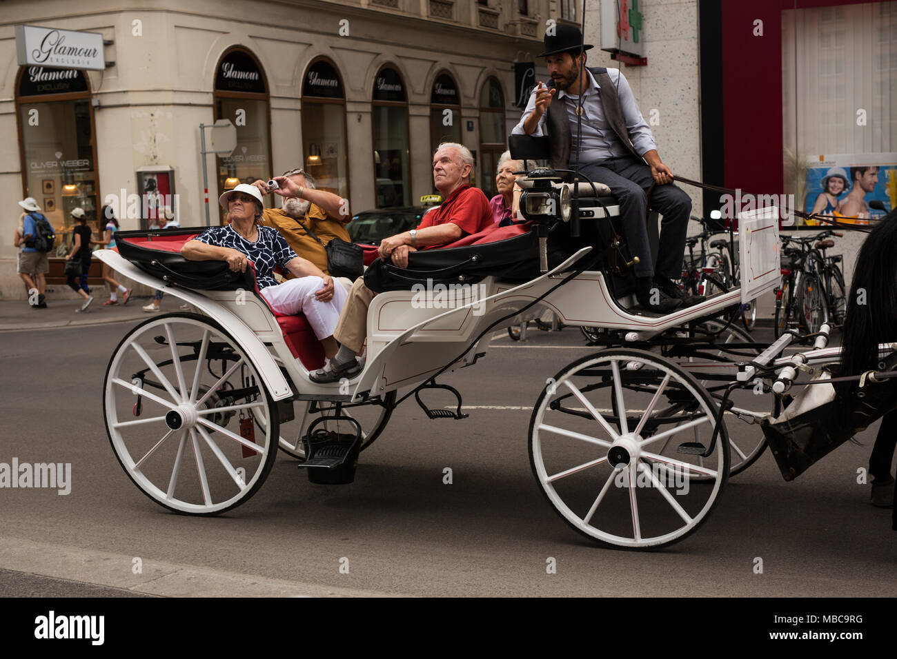 A horse-drawn carriage carries tourists around the streets of Vienna, Austria. Stock Photo