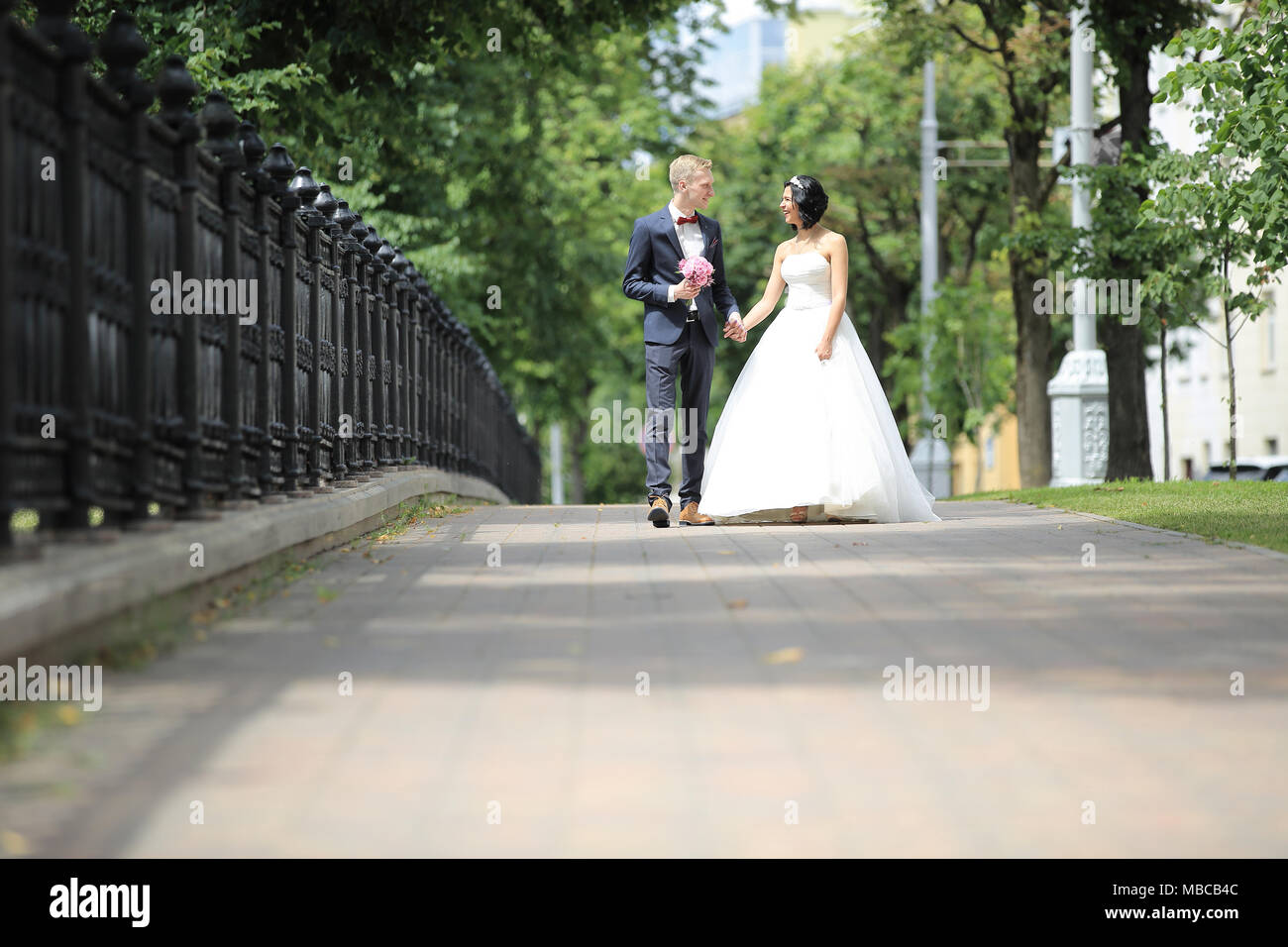 love the bride and groom walking around the city Stock Photo - Alamy