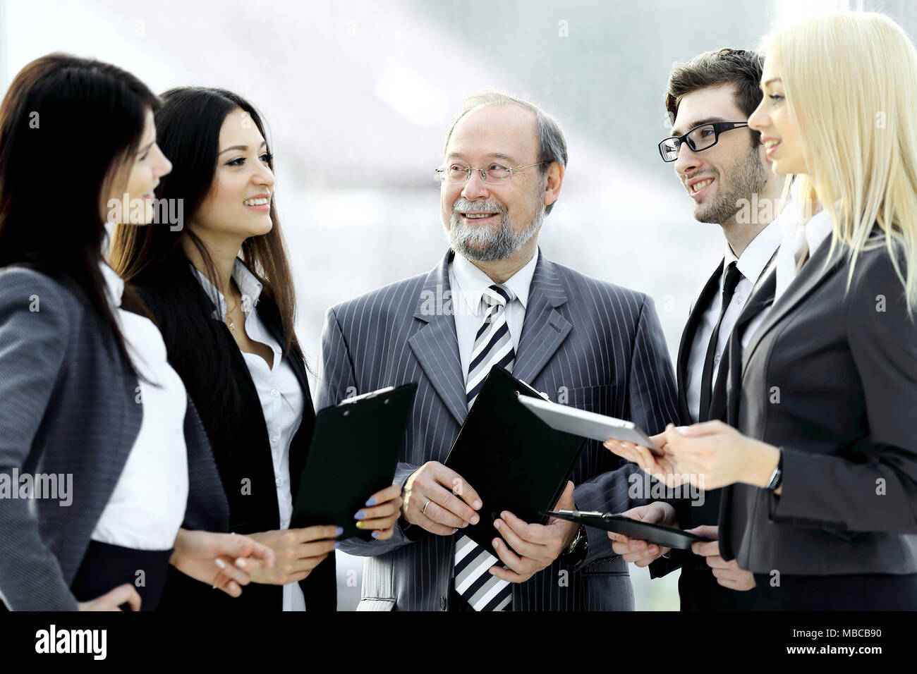 close up.a business team standing talking in the office Stock Photo - Alamy