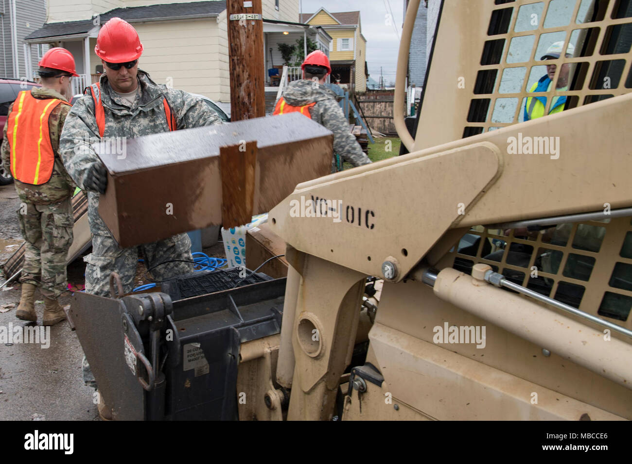 Sgt. Phillip Hickman, a heavy equipment operator with the 115th Vertical Construction Company, West Virginia National Guard, loads water damaged debris onto equipment for removal Feb. 19, 2018 on Wheeling Island, West Virginia in Ohio County. WVNG Soldiers provided equipment for small and large debris removal and helped local residents and city crews to remove more than 128 tons of debris from the area. (U.S. Air National Guard Stock Photo
