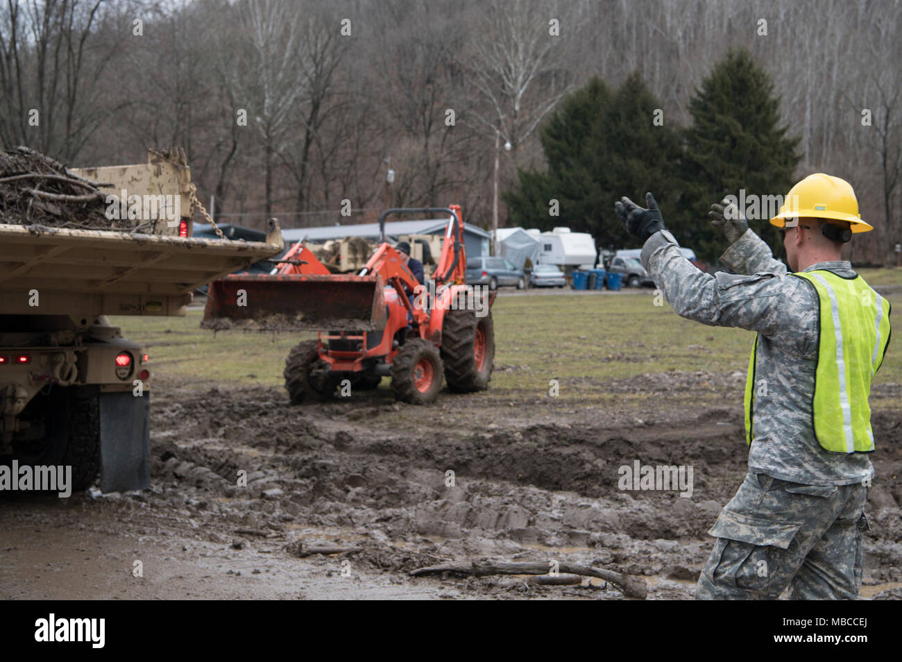 Staff Sgt. Kevin Smith, a combat engineer and non-commissioned officer in charge for the 119th Sapper Engineer Company, West Virginia National Guard, directs a truck loaded with debris in Ohio County, West Virginia Feb. 19, 2018, following flooding that impacted the area. WVNG Soldiers provided equipment for small and large debris removal and helped local residents and city crews to remove more than 128 tons of debris from the area. (U.S. Air National Guard Stock Photo