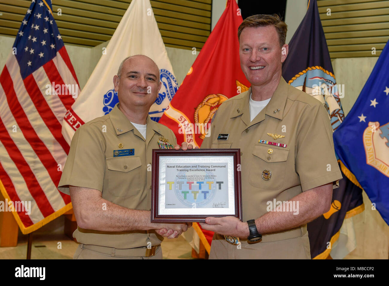 Fla. (Feb. 20, 2018) Rear Adm. Kyle Cozad (right), commander, Naval Education and Training Command (NETC), presents the 2017 NETC Training Excellence Award to Capt. Bill Lintz, commanding officer, Center for Information Warfare Training (CIWT). CIWT won the overall Training Excellence White 'T' award and all nine functional area awards. (U.S. Navy Stock Photo