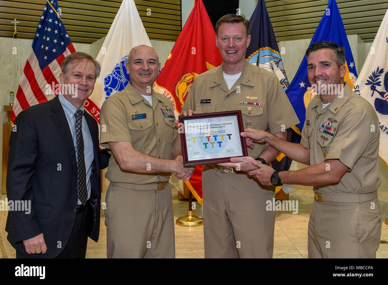 Fla. (Feb. 20, 2018) Rear Adm. Kyle Cozad (second from right), commander, Naval Education and Training Command (NETC), presents the 2017 NETC Training Excellence Award to Capt. Bill Lintz, commanding officer, Center for Information Warfare Training (CIWT). CIWT won the overall Training Excellence White 'T' award and all nine functional area awards. Also pictured are John Jones, NETC’s executive director (far left), and CIWT's Command Master Chief Mike Bates (far right). (U.S. Navy Stock Photo
