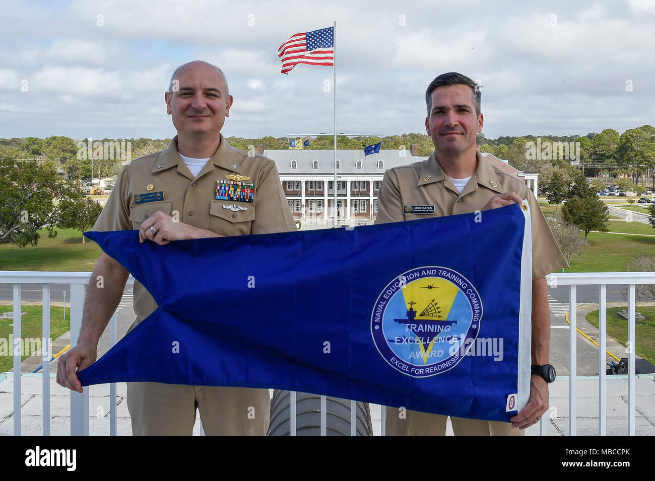 Fla. (Feb. 20, 2018)  Capt. Bill Lintz, commanding officer, Center for Information Warfare Training (CIWT) and CIWT Command Master Chief Mike Bates pose with the 2017 NETC Training Excellence Award blue burgee. CIWT won the overall Training Excellence White 'T' award, all nine functional area awards and is authorized to display the burgee throughout 2018. (U.S. Navy Stock Photo