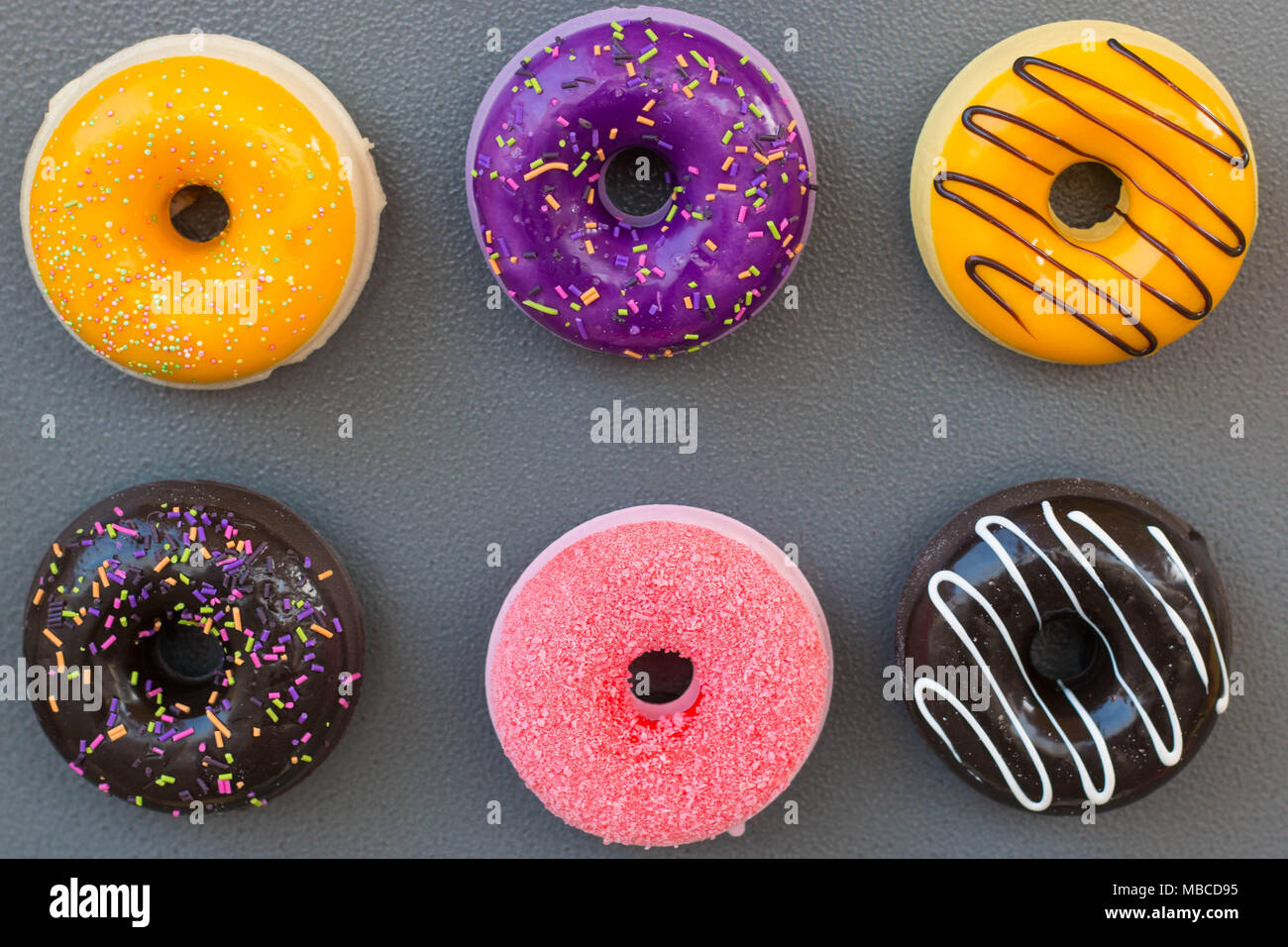 Donuts shaped magnets on grey background. Different colors magnets, junk  food symbol Stock Photo - Alamy