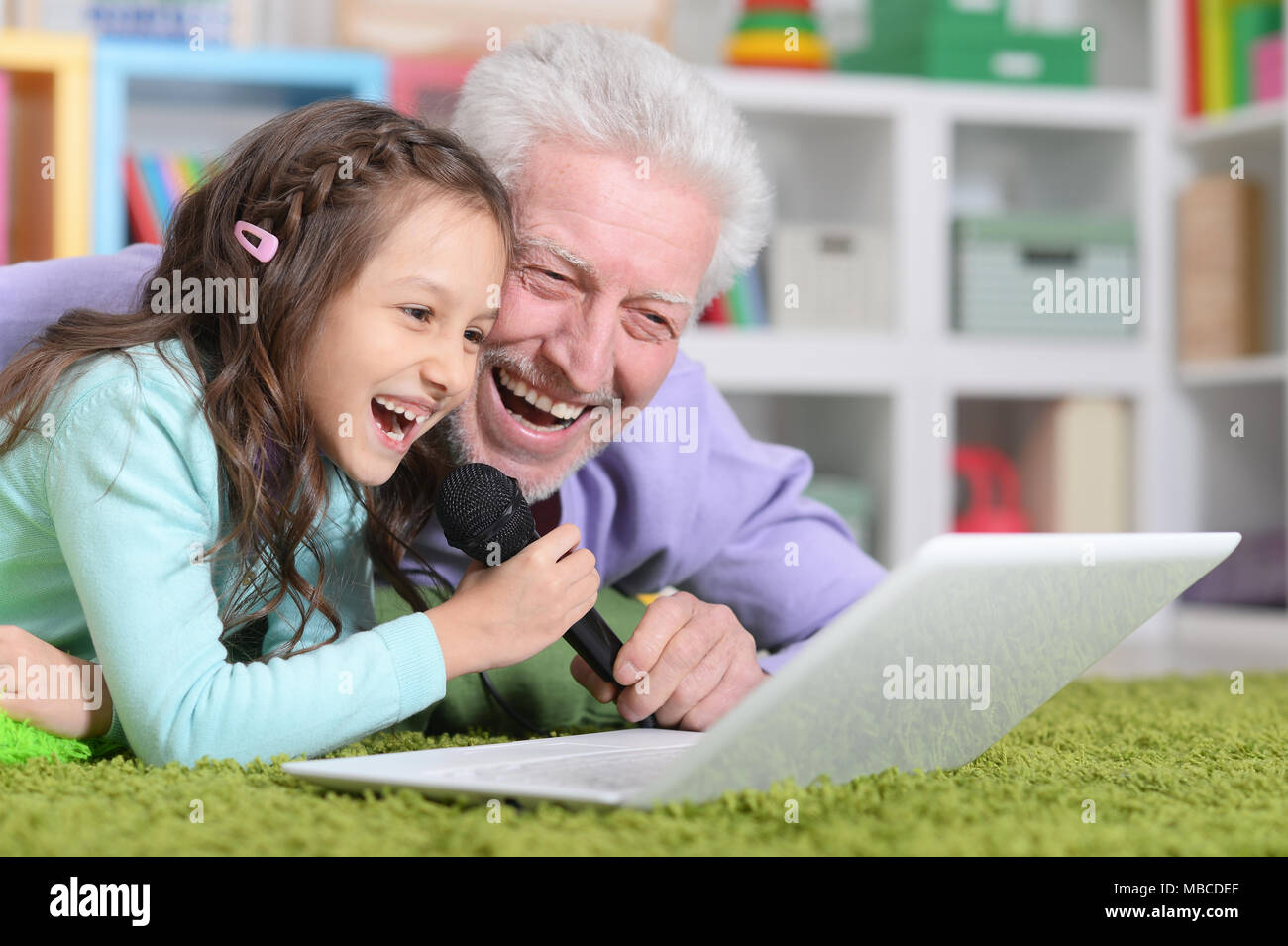 happy grandfather and child singing karaoke Stock Photo
