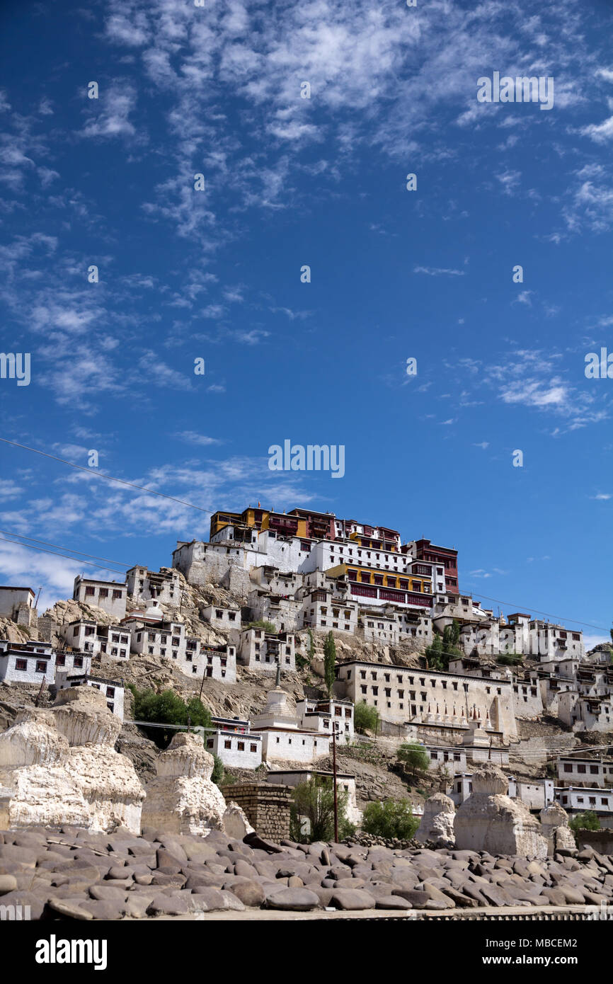 Set on a steep ridge, Thiksay Monastery makes an imposing feature of the landscape.  Perfectly blue skies are highlighted by a few wispy white clouds Stock Photo