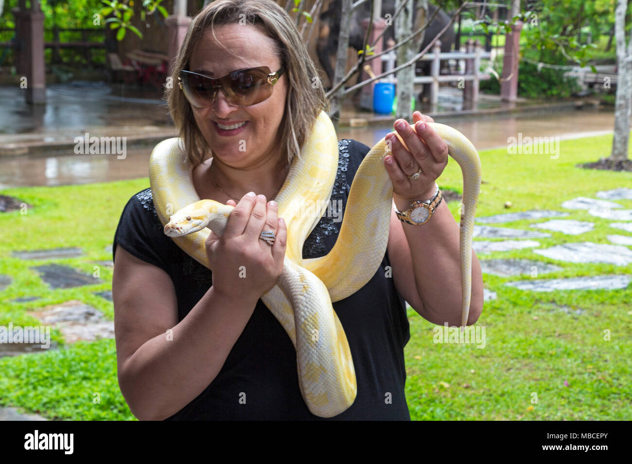 Tourist posing with snake at Rose Garden, Nakhon Pathom, Bangkok Stock Photo