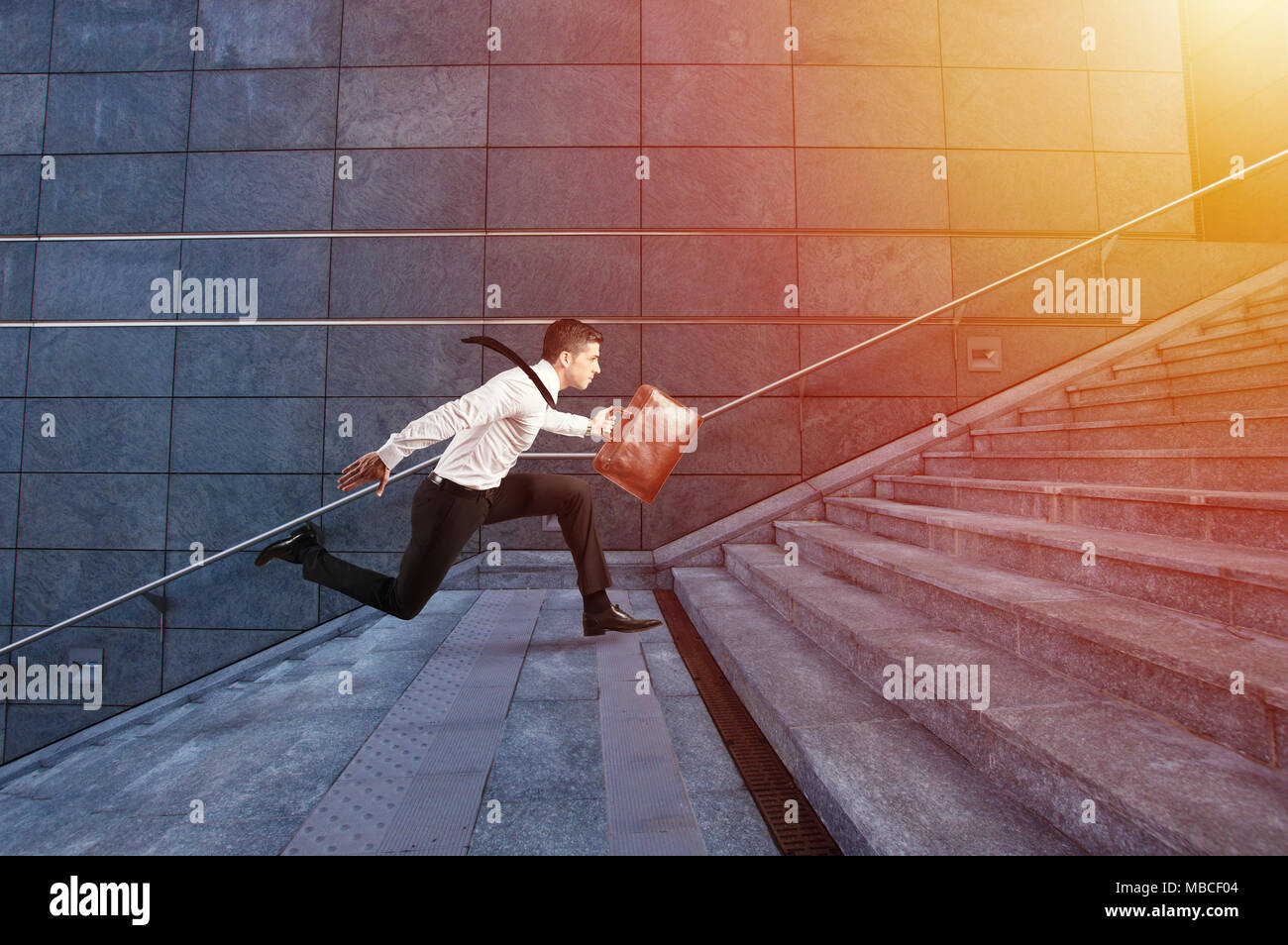 Businessman runs fast over a modern staircase Stock Photo