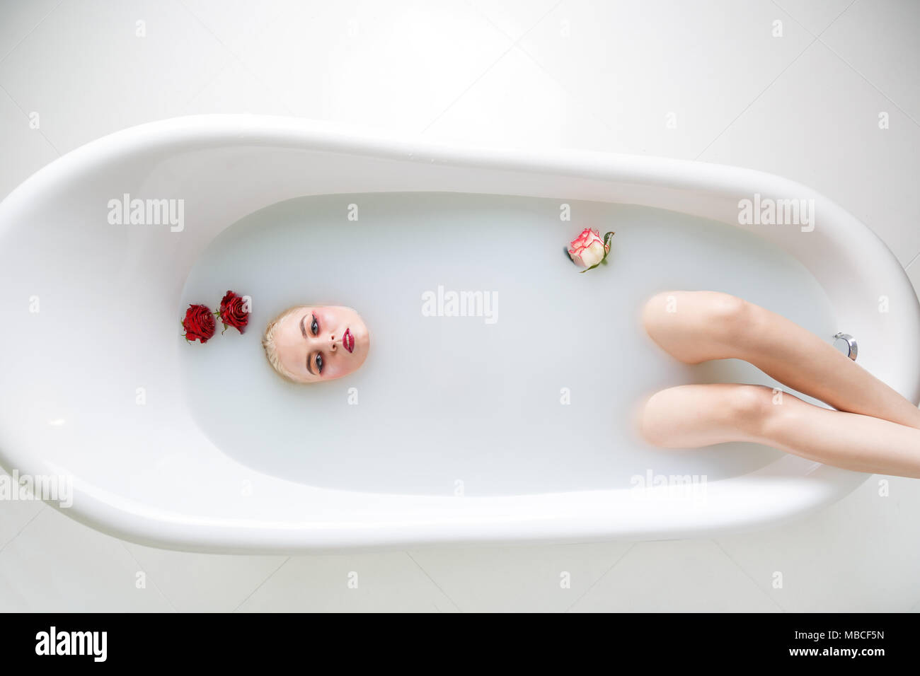 Beautiful young woman taking bath with milk Stock Photo Alamy