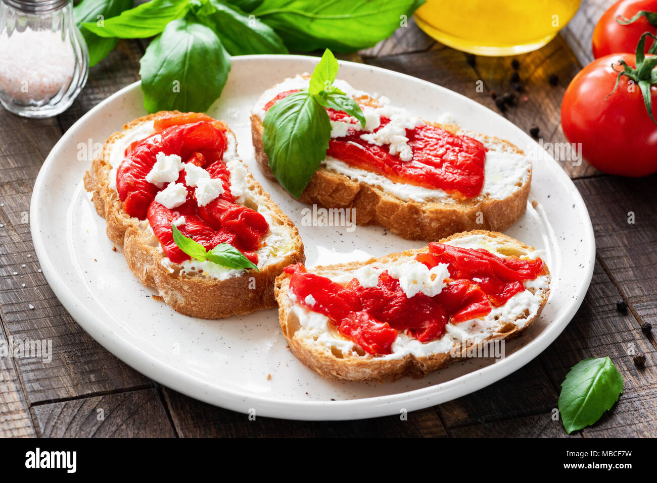 Italian antipasti bruschetta with roasted pepper, olive oil and goat cheese or feta cheese. Rustic style. Selective focus Stock Photo