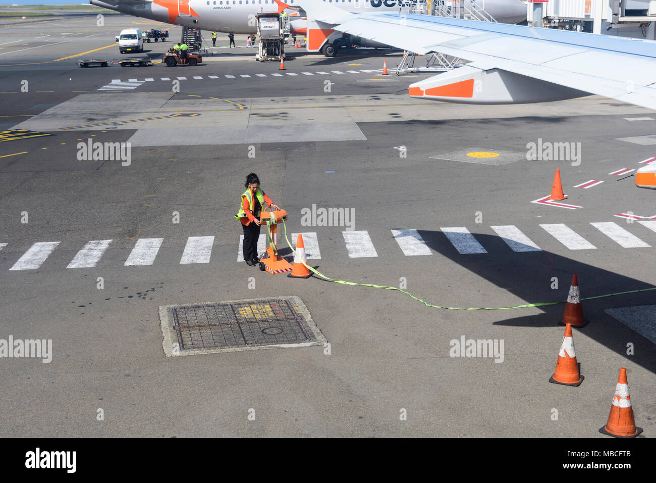 Ground Staff setting the passengers limit around an aircraft on the tarmac at Sydney Airport, Australia Stock Photo