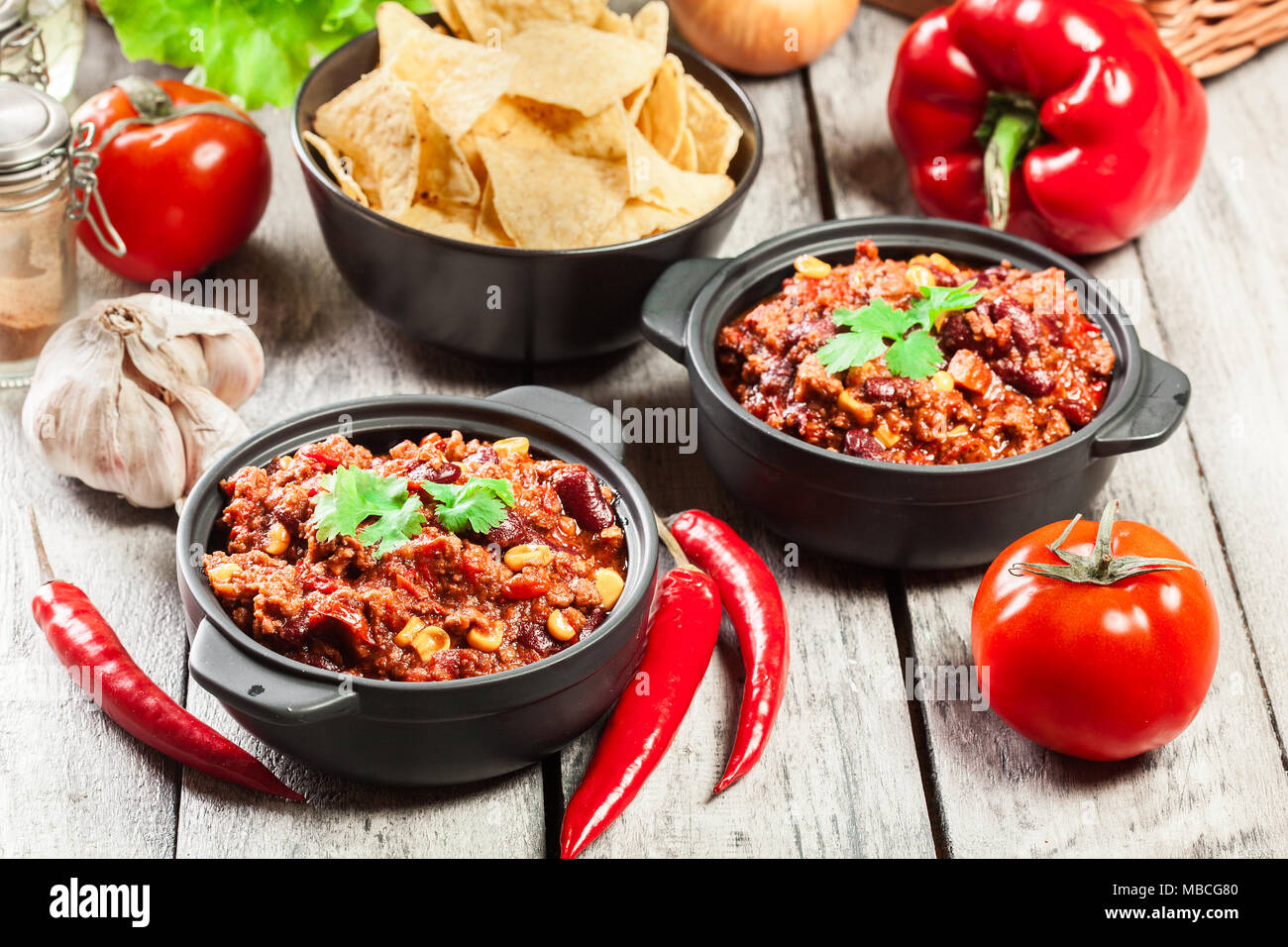 Bowls of hot chili con carne with ground beef, beans, tomatoes and corn
