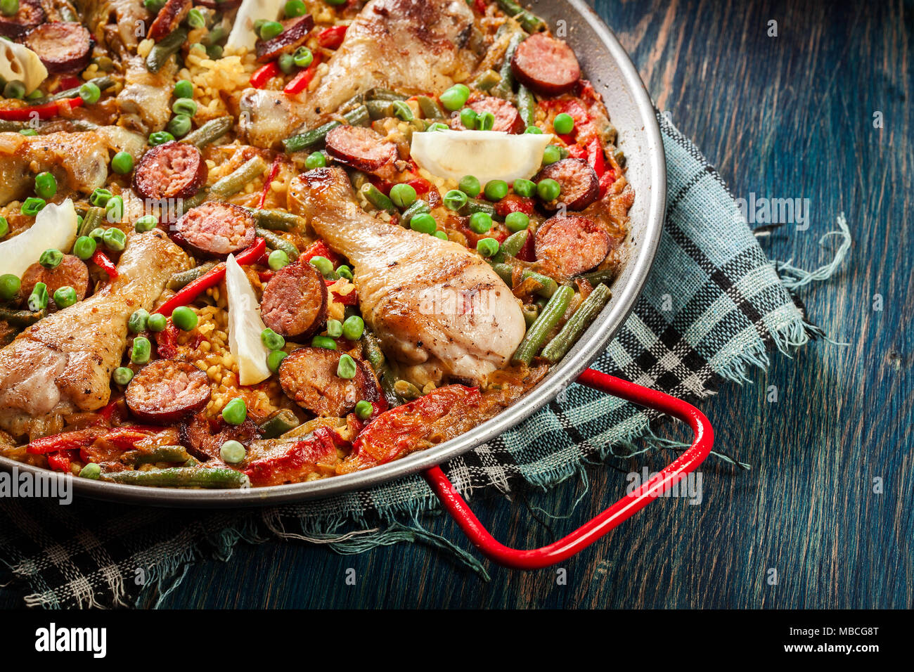 Traditional paella with chicken legs, sausage chorizo and vegetables
