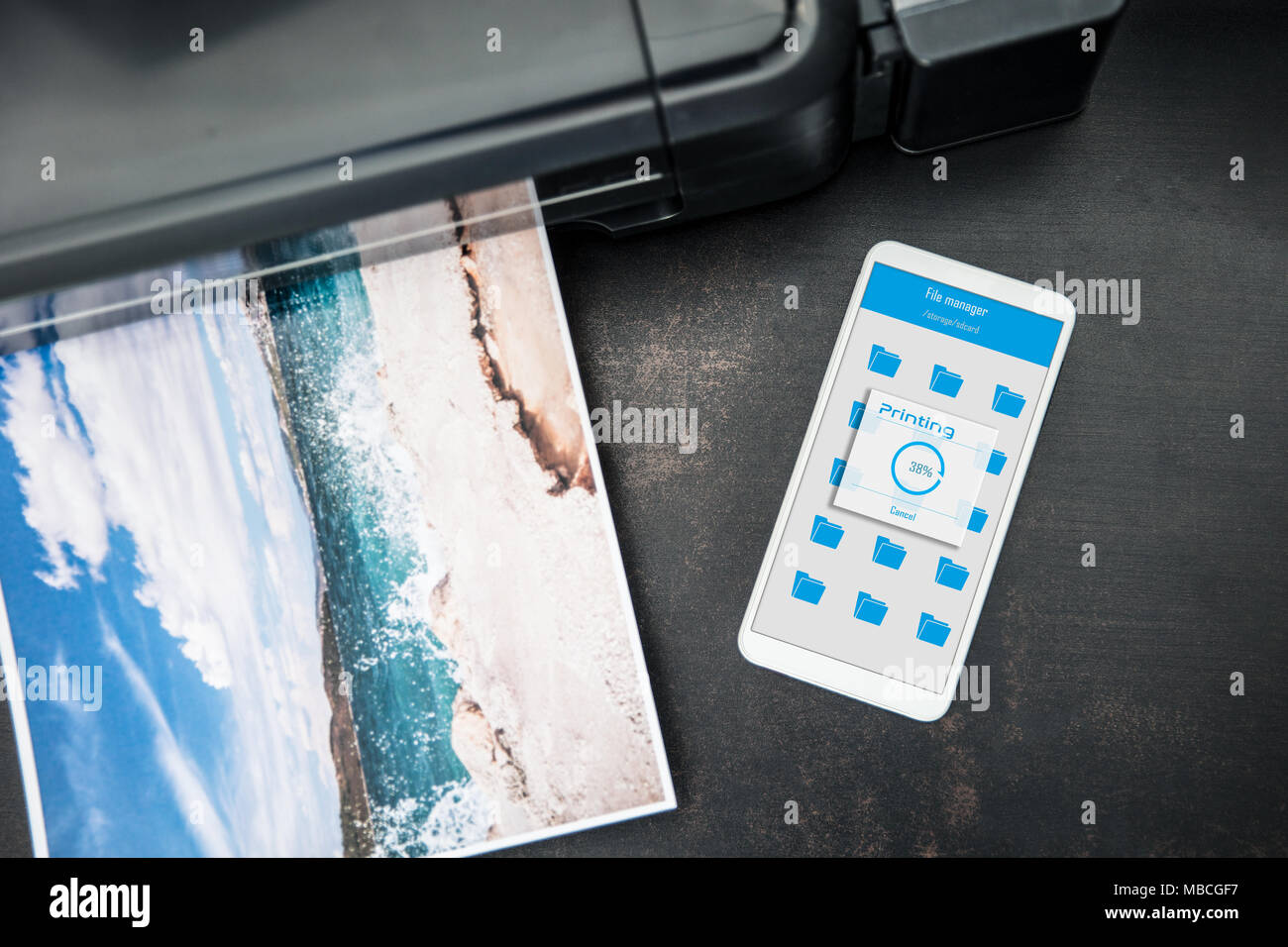 Smartphone connected to the wireless printer is laying on the desk Stock Photo