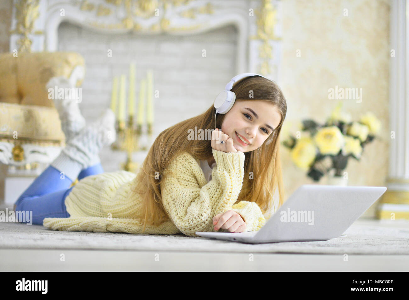 Beautiful teen girl lying on floor and using laptop Stock Photo - Alamy
