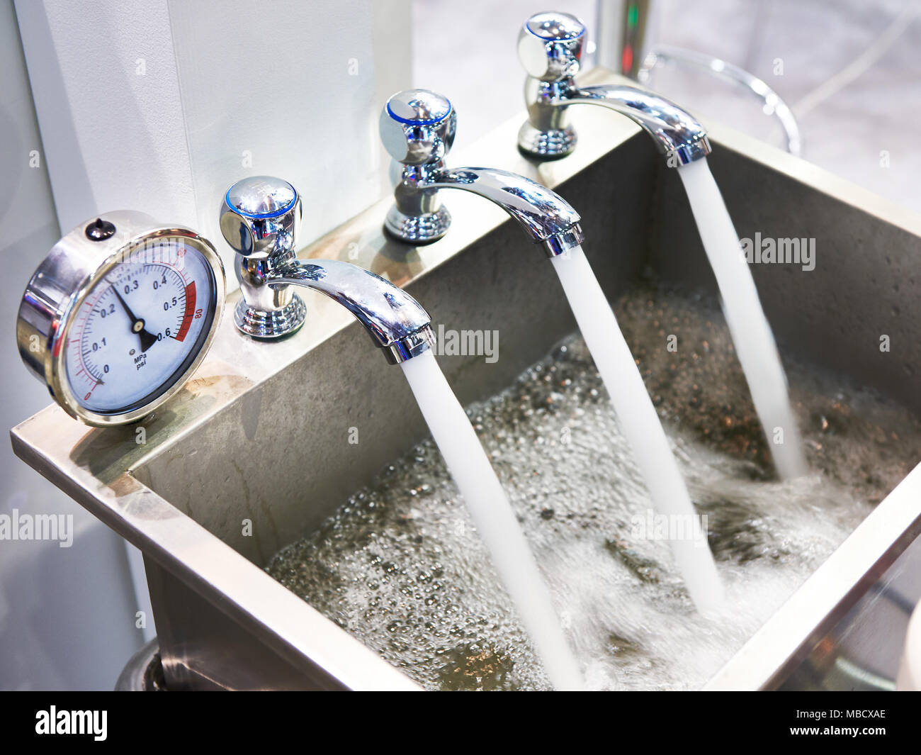 Metal sink with three taps and a manometer Stock Photo