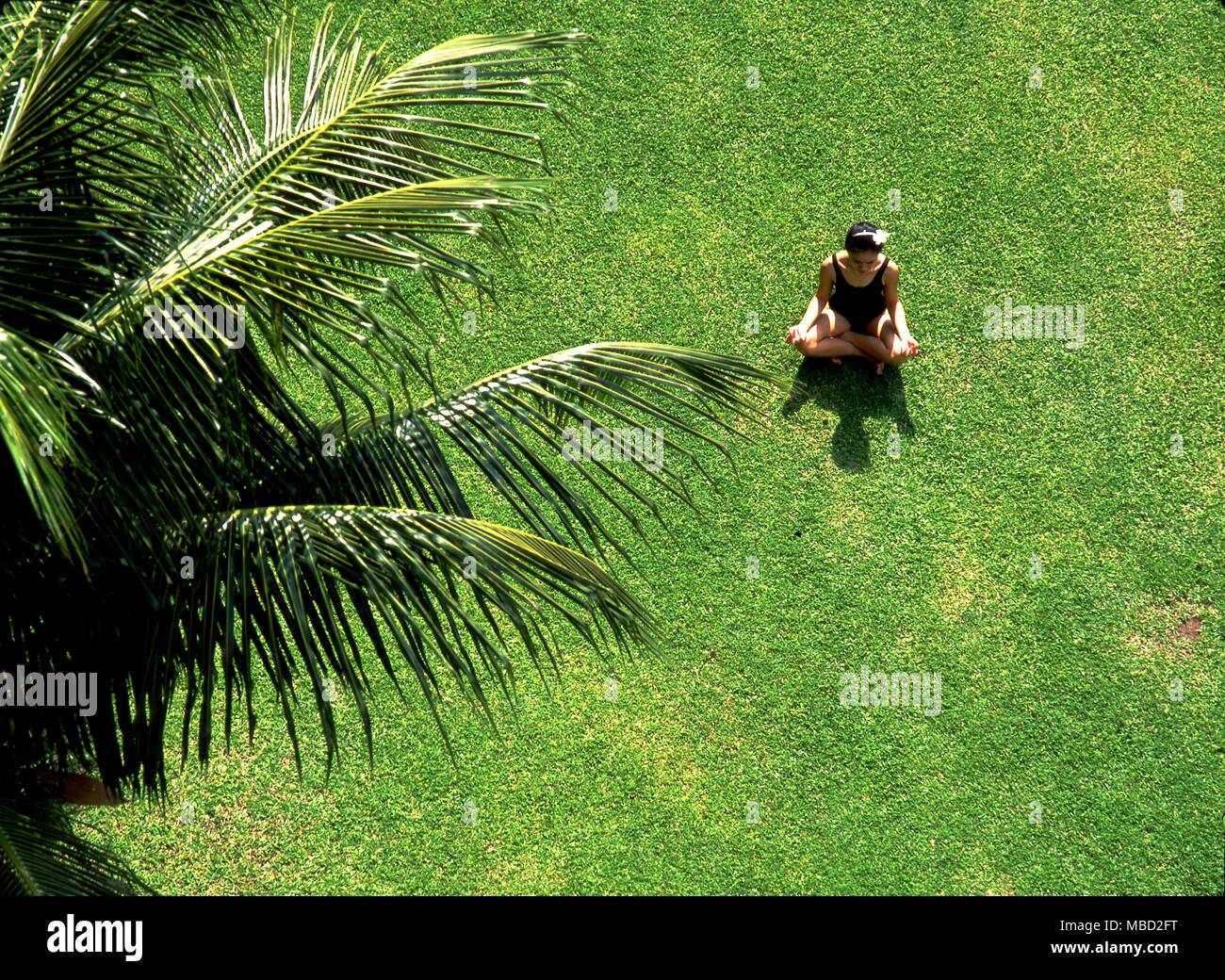Girl meditating in a yoga position on the lawn Stock Photo - Alamy