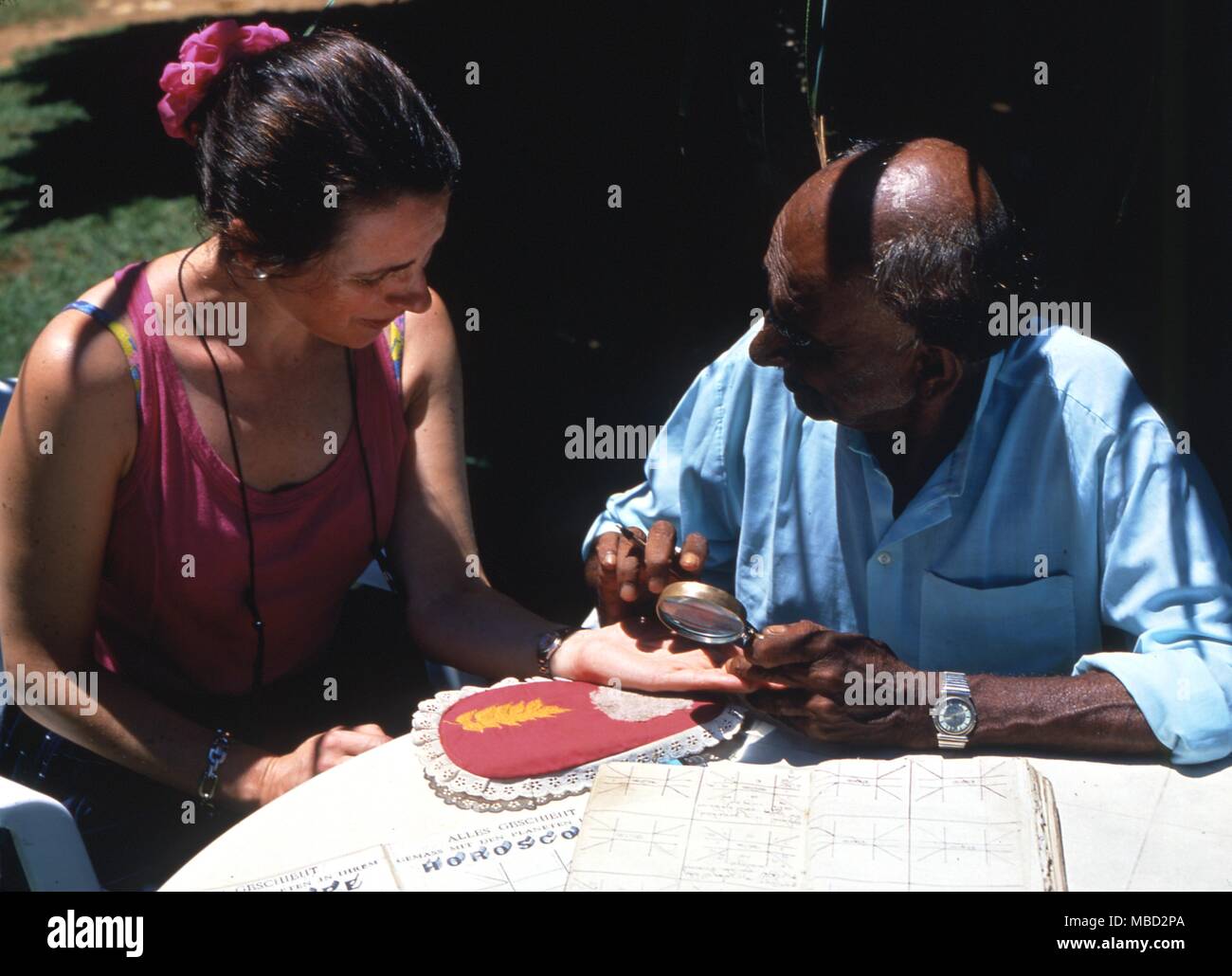 Palmistry - Sri Lankan palmist reading the hand of a tourist in the gardens of an hotel. - © / CW Stock Photo