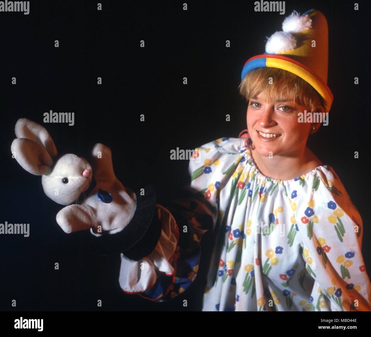 Clowns - throwing things into thin air - this clown-magician takes a toy bunny from her magic hat and throws it to the left - the bunny disappears. - © / Charles Walker Stock Photo