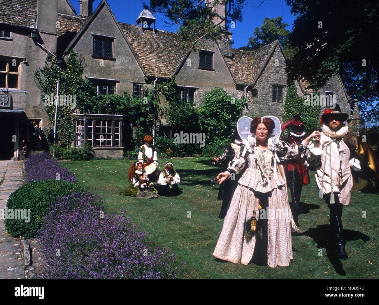 A modern group of actors in 17th century costume outside a manor house. Stock Photo