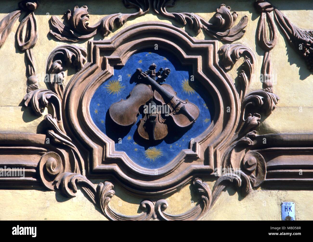 Symbols - Violins. Decorative bas relief on the Nerudova in Prague, Czech Republic.The three little fiddles recalls the fact that between 1667 and 1748, the house belonged to three generations of violin makers. Stock Photo