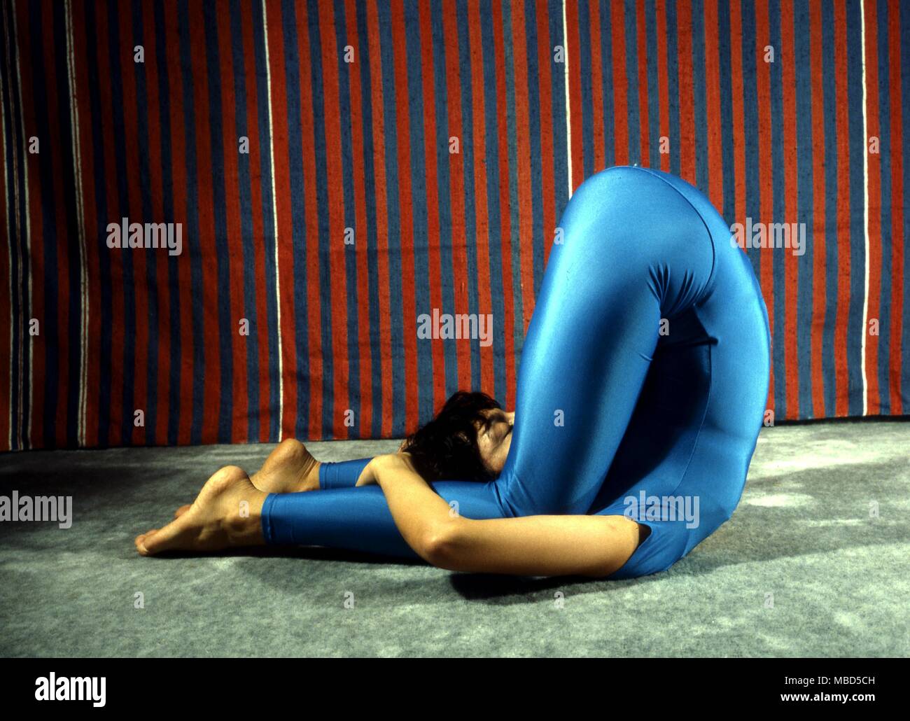 Yoga positions. The Karnapadasana. Stock Photo