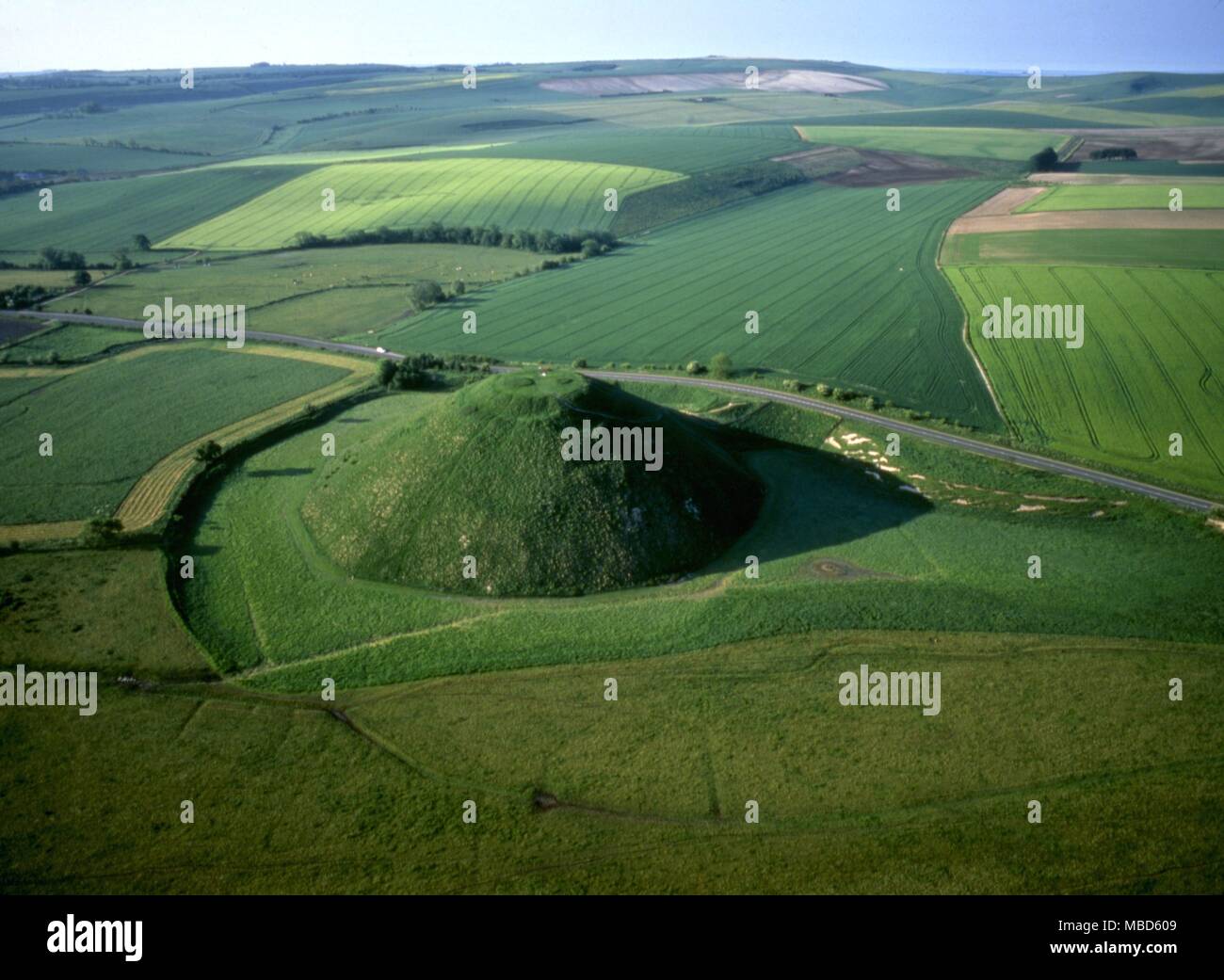 Silbury Hill This man made mound is 130 feet high and covers just over 5 acres. The flat top is 100 feet across. Constructed circa 2100 BC and clearly linked with nearby Avebury circles . Stock Photo