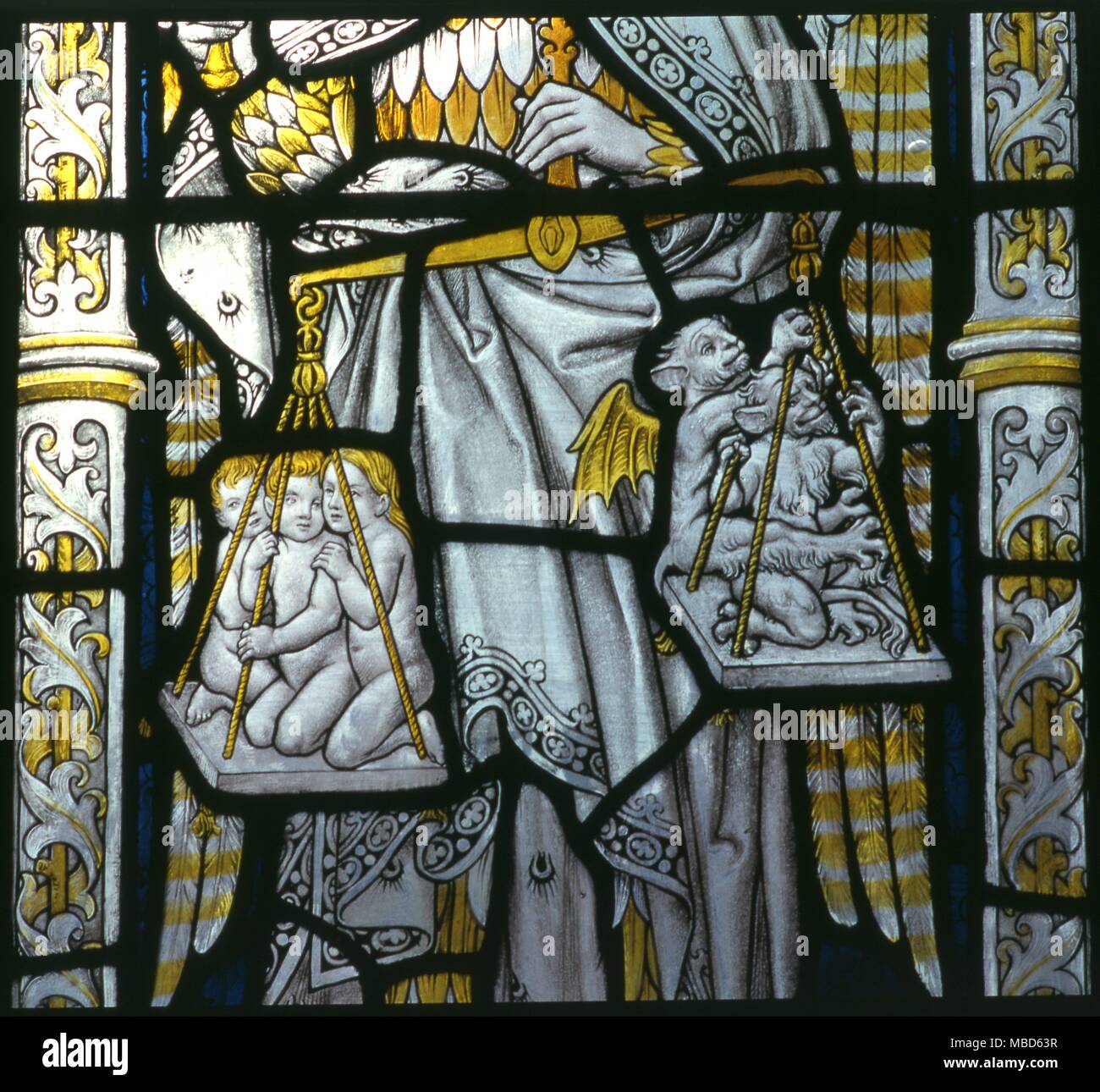 Christian - Human souls Newly departed souls in the balance of the archangel Michael, being balanced against demonic sins. From the cloister windows of Chester Cathedral, dated c 1921 - 28 Stock Photo