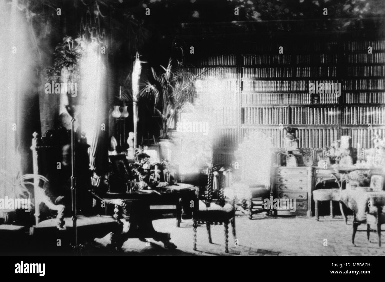 GHOSTS - SPIRIT PHOTOS The Ghost of Lord Combermere. One of the most famous of all spirit photographs, this was taken in the library of Combermere Abbey, in 1891, by Sybell Corbet, an amateur photographer. The library was empty when she took the photograph (she remained there during the long exposure), yet when the plate was developed, the image of an old man, seated in the high-back chair to the left, was quite visible. It turned out that at the time the picture was being taken, Lord Combermere was being buried at Wrenbury, a few miles from the Abbey. It was observed that the ghost had n Stock Photo